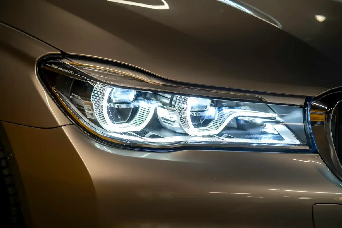 Gros plan d'un phare avant LED de berline premium, capot et aile visibles
